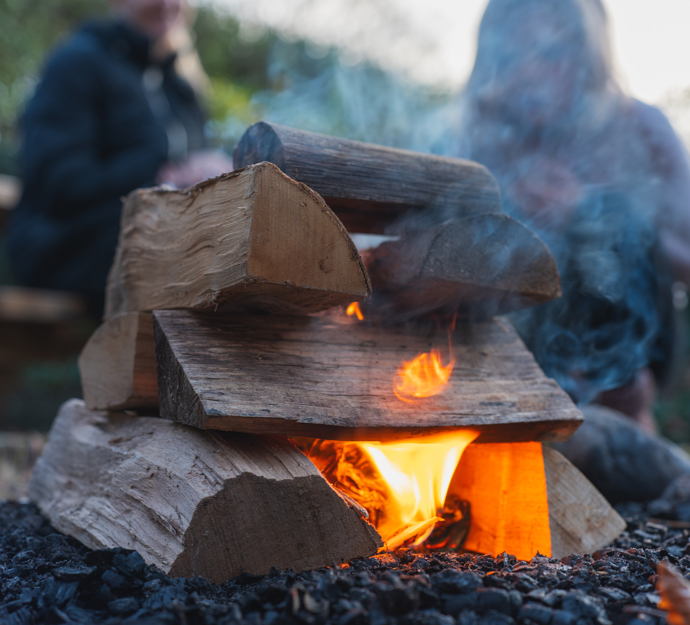 Barn og voksen ved bål