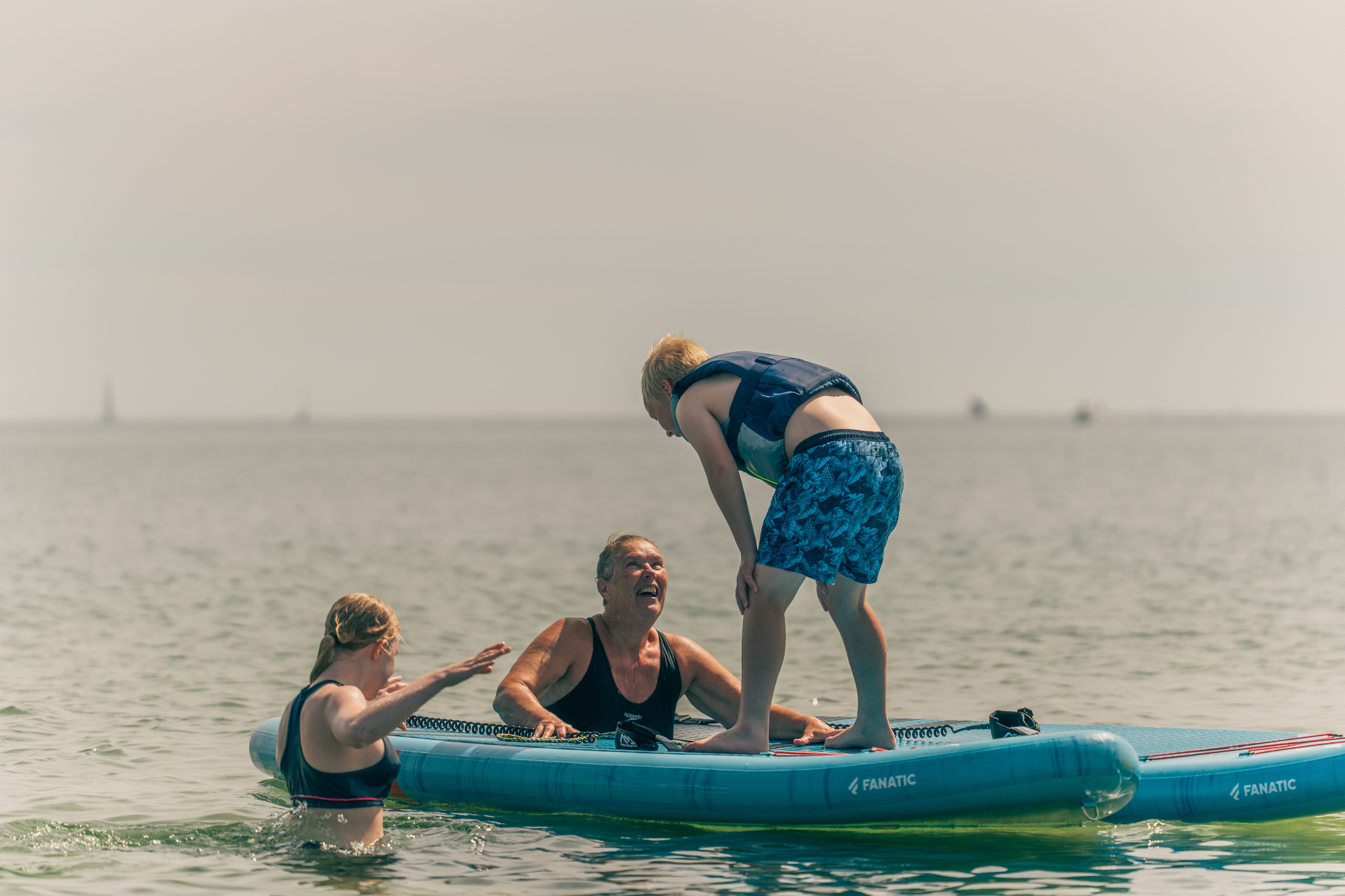 Børn og voksne i vandet på padleboard